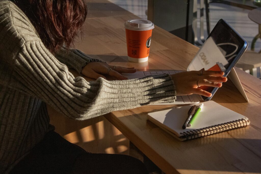 A warm, inviting workspace featuring a tablet, coffee cup, and notebook at an Istanbul cafe.