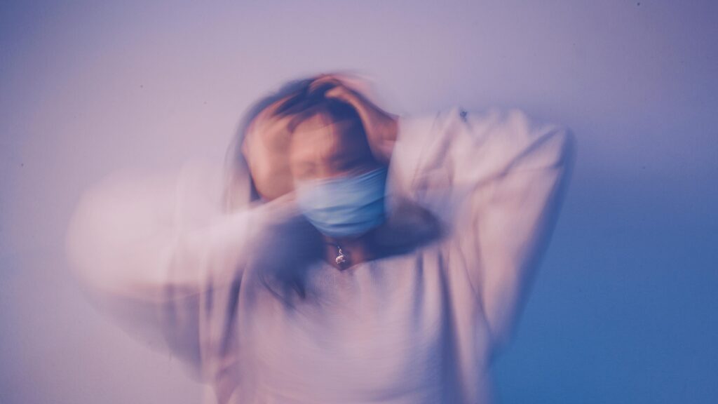 Blurred motion of woman in mask representing pandemic stress and anxiety.